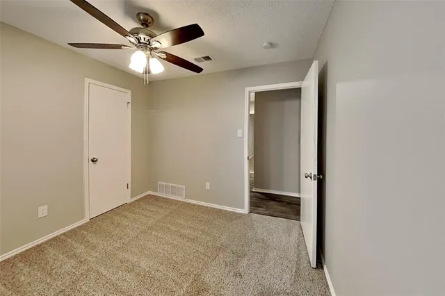 an empty room with closet and fan