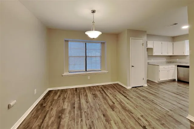 a view of a room with wooden floor and a window
