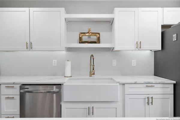 a kitchen with stainless steel appliances a stove and white cabinets