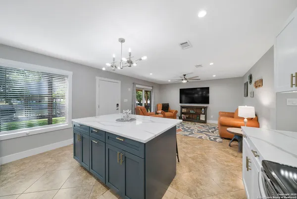 a living room with furniture kitchen view and a flat screen tv