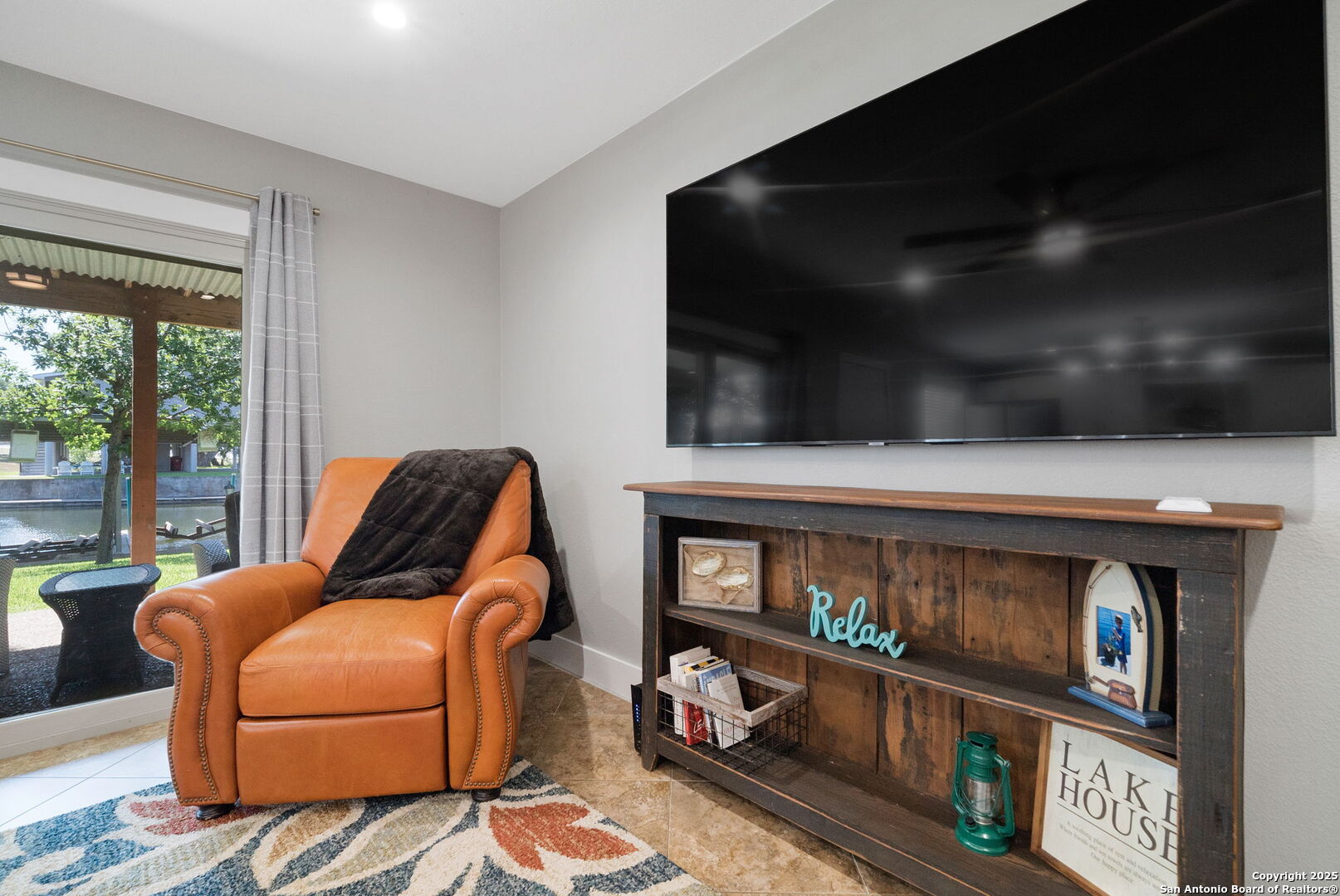 1500 Ranch Road 1431, Unit 103 Kingsland, TX 78639 - Photo 19 of 29 a living room with furniture a flat screen tv and a floor to ceiling window