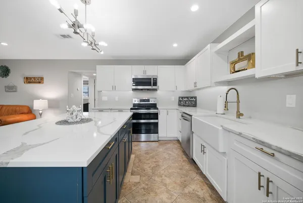 a kitchen with kitchen island a sink appliances and cabinets