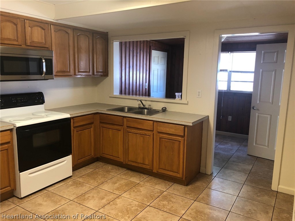 313 Heard Bridge Road Wauchula, FL 33873 - Photo 5 of 20 a kitchen with stainless steel appliances granite countertop a stove a sink and a microwave