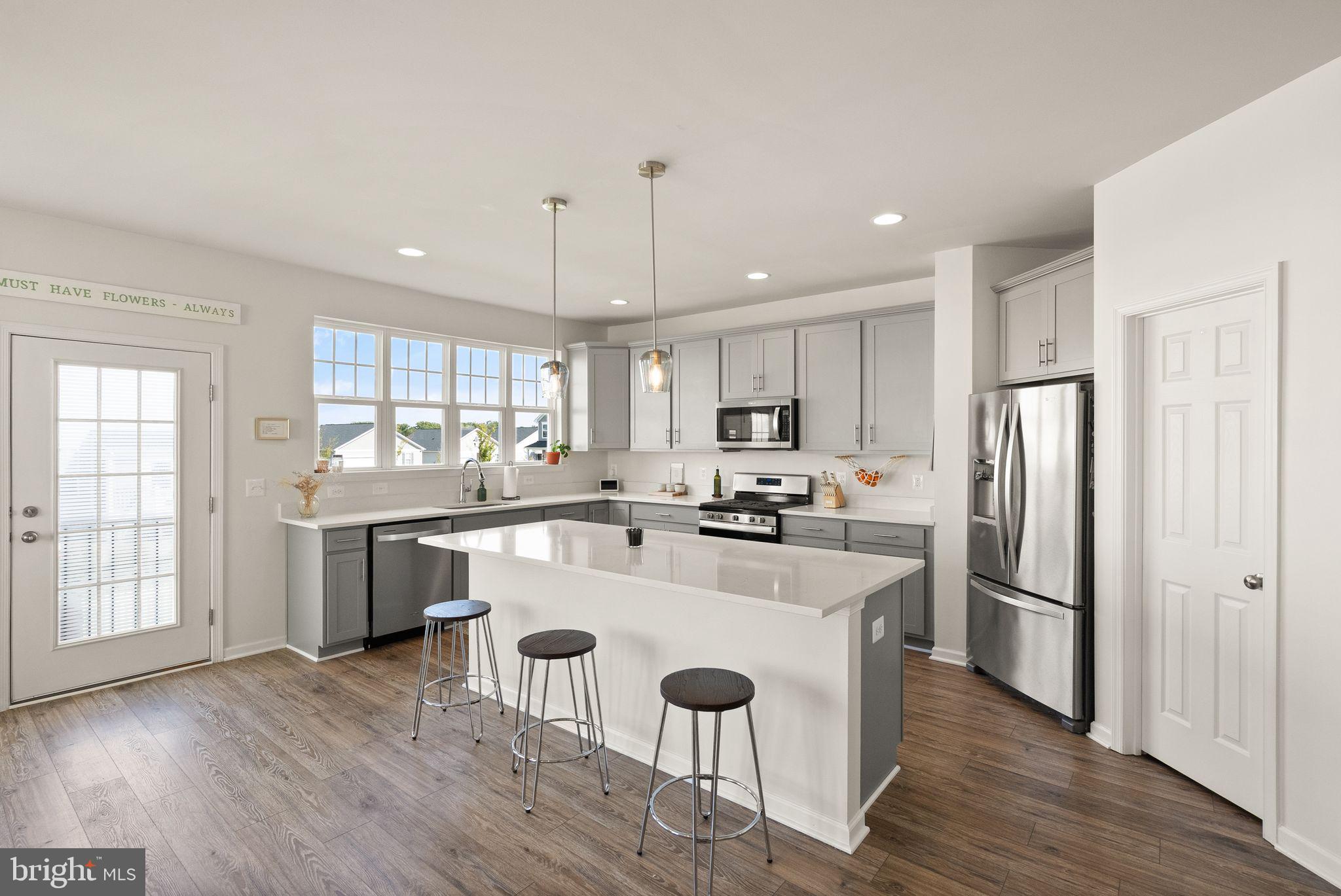 131 Interlace Way Stephenson, VA 22656 - Photo 10 of 71 a kitchen with a center island wooden floor and stainless steel appliances