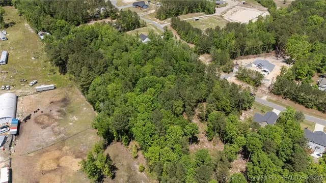 an aerial view of residential house with outdoor space and trees all around