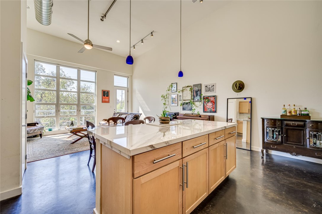 1601 East Cesar Chavez Street, Unit 312 Austin, TX 78702 - Photo 1 of 1 a open kitchen with stainless steel appliances granite countertop a sink dishwasher a stove and a dining table with wooden floor