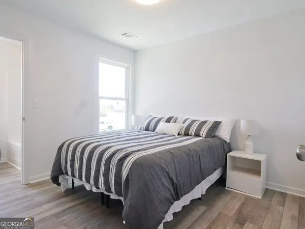 a bedroom with a bed and wooden floor