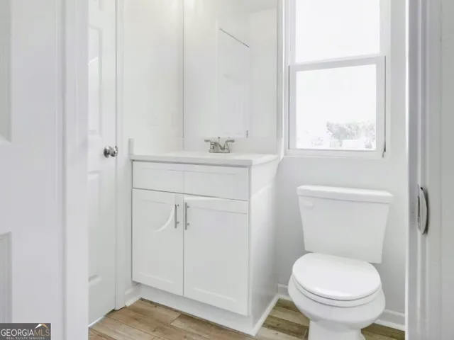 a bathroom with a toilet a sink and a window