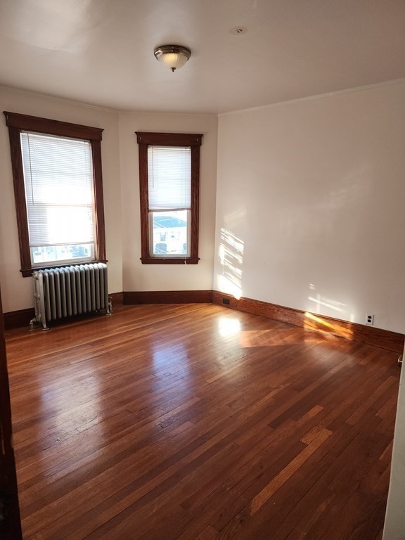 57 Austin Street, Unit 2 Boston, MA 02136 - Photo 7 of 17 an empty room with wooden floor and windows