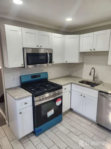 a kitchen with cabinets stainless steel appliances and a sink