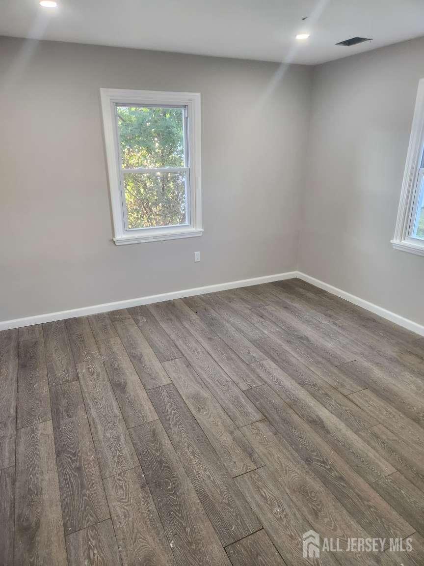 223 Plainfield Avenue Edison, NJ 08817 - Photo 6 of 6 an empty room with wooden floor and windows