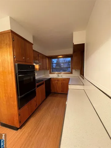 a kitchen with stainless steel appliances wooden cabinets and a stove top oven