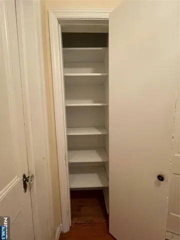 a view of walk in closet with empty racks