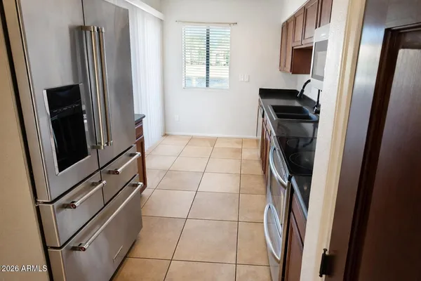 a view of a refrigerator and an empty room in a kitchen