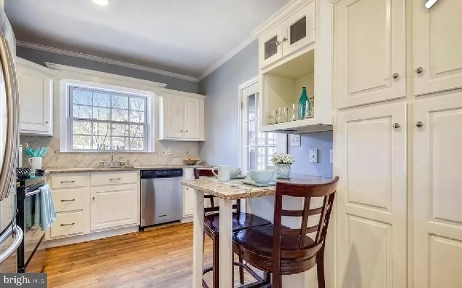 5806 Kenmore Road Baltimore, MD 21210 - Photo 12 of 35 a kitchen with stainless steel appliances granite countertop a stove a sink dishwasher and cabinets with wooden floor