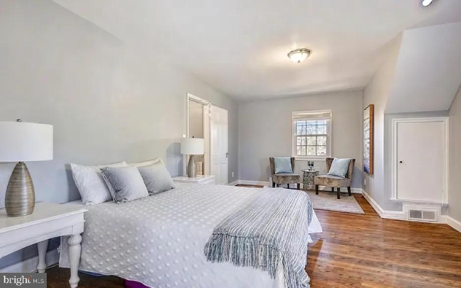 5806 Kenmore Road Baltimore, MD 21210 - Photo 17 of 35 a bedroom with a bed and wooden floor