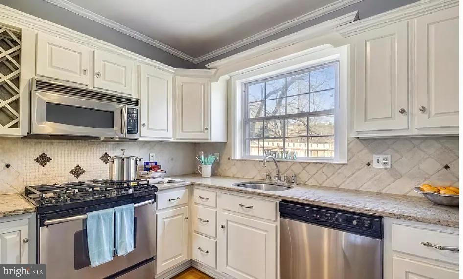 5806 Kenmore Road Baltimore, MD 21210 - Photo 10 of 35 a kitchen with stainless steel appliances granite countertop white cabinets sink and window