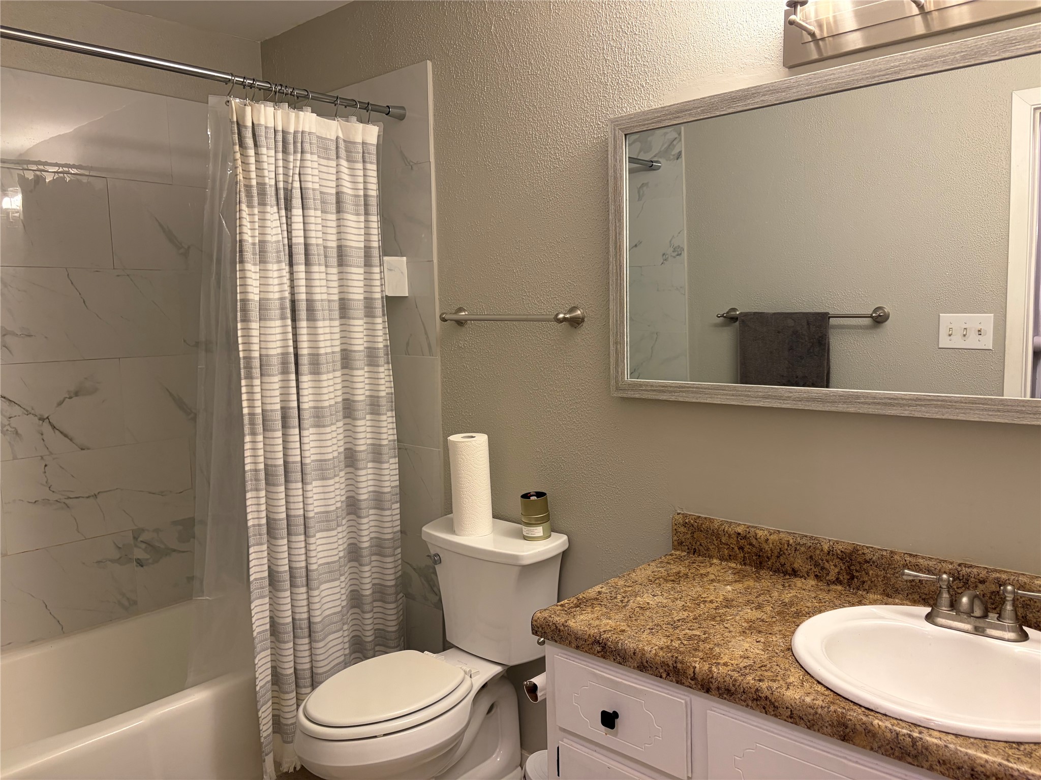 1400 Vista Ridge Cove, Unit B Austin, TX 78754 - Photo 14 of 25 A well-maintained bathroom with a sleek vanity and tiled shower offers a clean, contemporary feel.