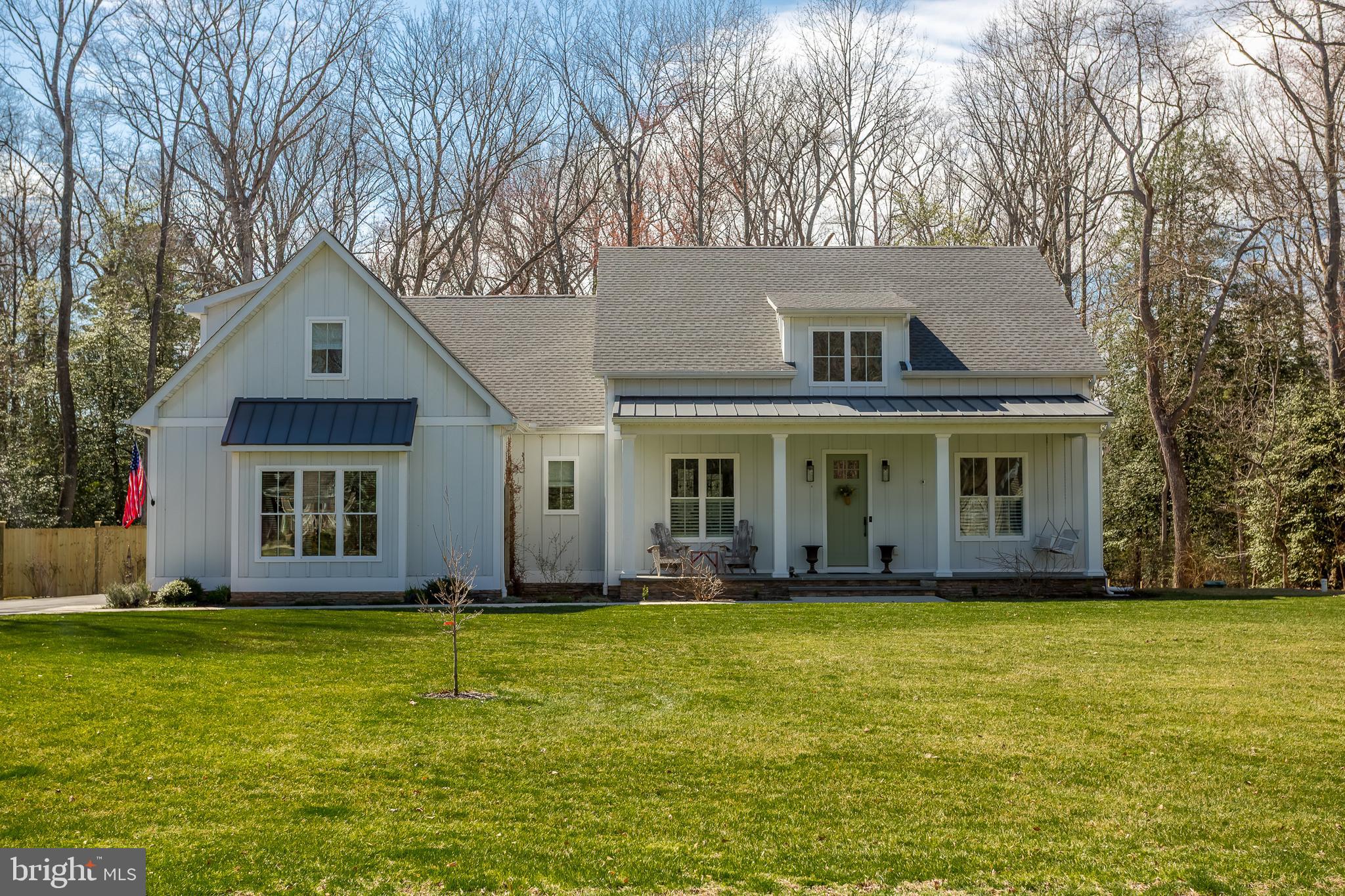 a front view of house with yard and trees in the background