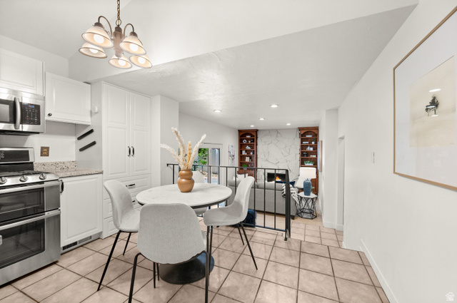 2163 Borg Drive Sandy, UT 84092 - Photo 10 of 31 Dining area with light tile patterned floors, a fireplace, and hanging lights
