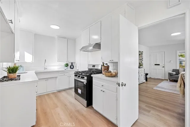 a kitchen with stainless steel appliances sink stove top oven and cabinets