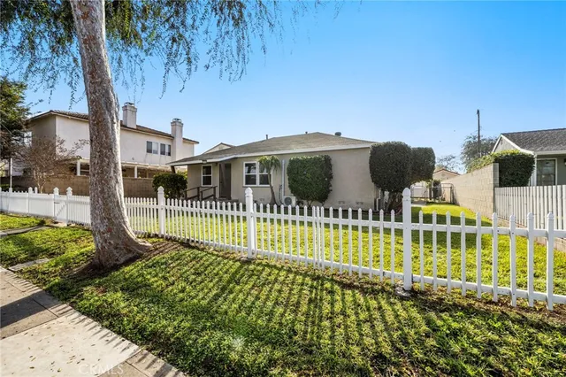 a view of a house with a wooden deck and a yard