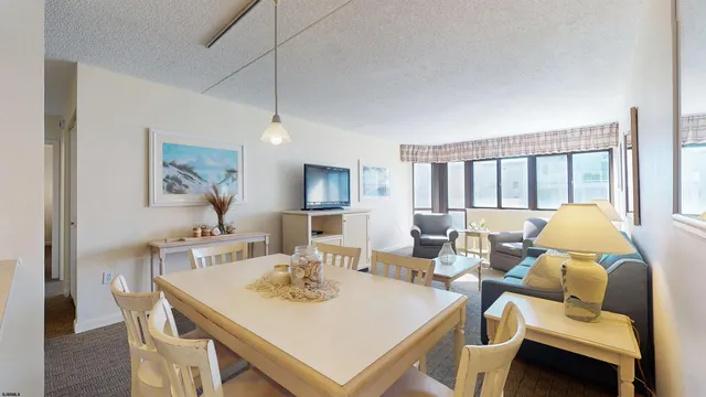 a view of a dining room with furniture a chandelier and wooden floor