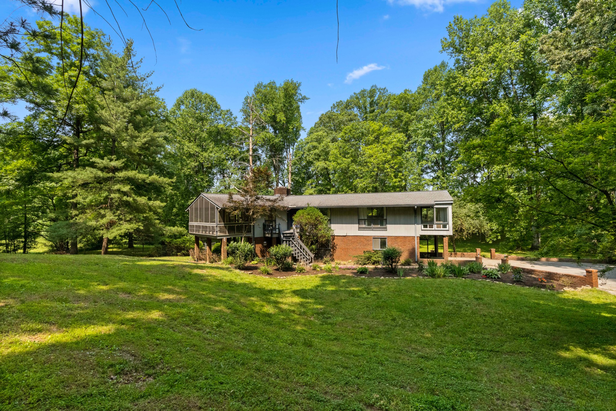 a view of a backyard with table and chairs and a large tree