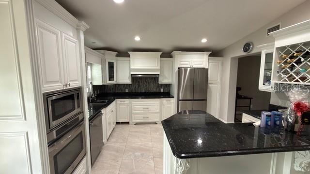 633 Spring Oaks Boulevard Altamonte Springs, FL 32714 - Photo 10 of 37 a kitchen with stainless steel appliances granite countertop a sink a stove and a refrigerator
