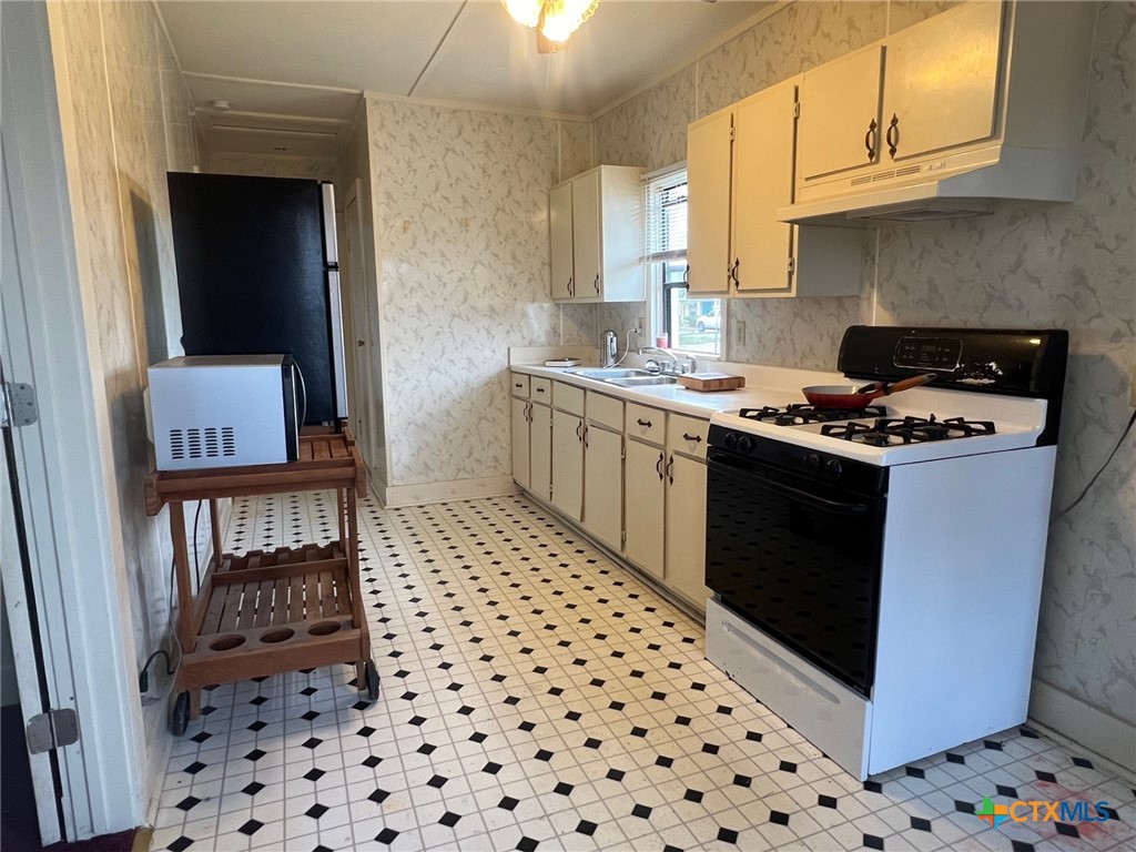 327 West Main Street Port Lavaca, TX 77979 - Photo 4 of 11 a kitchen with a sink a stove and cabinets