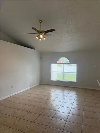 a view of a livingroom with a ceiling fan and window