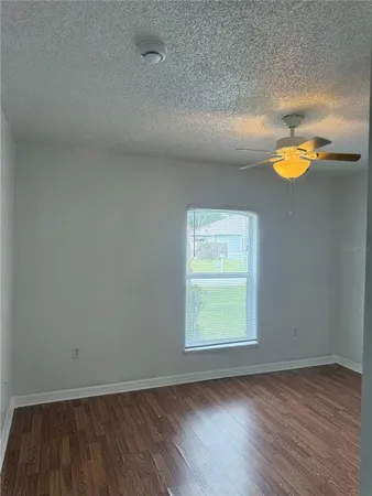 an empty room with wooden floor and window