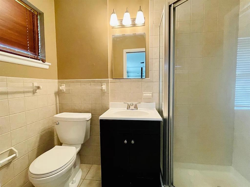 3152 Walnut Hill Lane Dallas, TX 75229 - Photo 15 of 18 a bathroom with a toilet sink and mirror