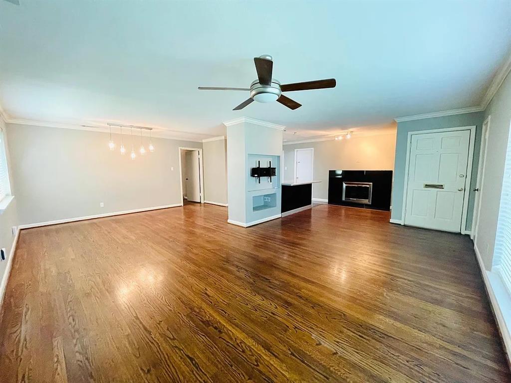 3152 Walnut Hill Lane Dallas, TX 75229 - Photo 6 of 18 a view of empty room with wooden floor and fireplace
