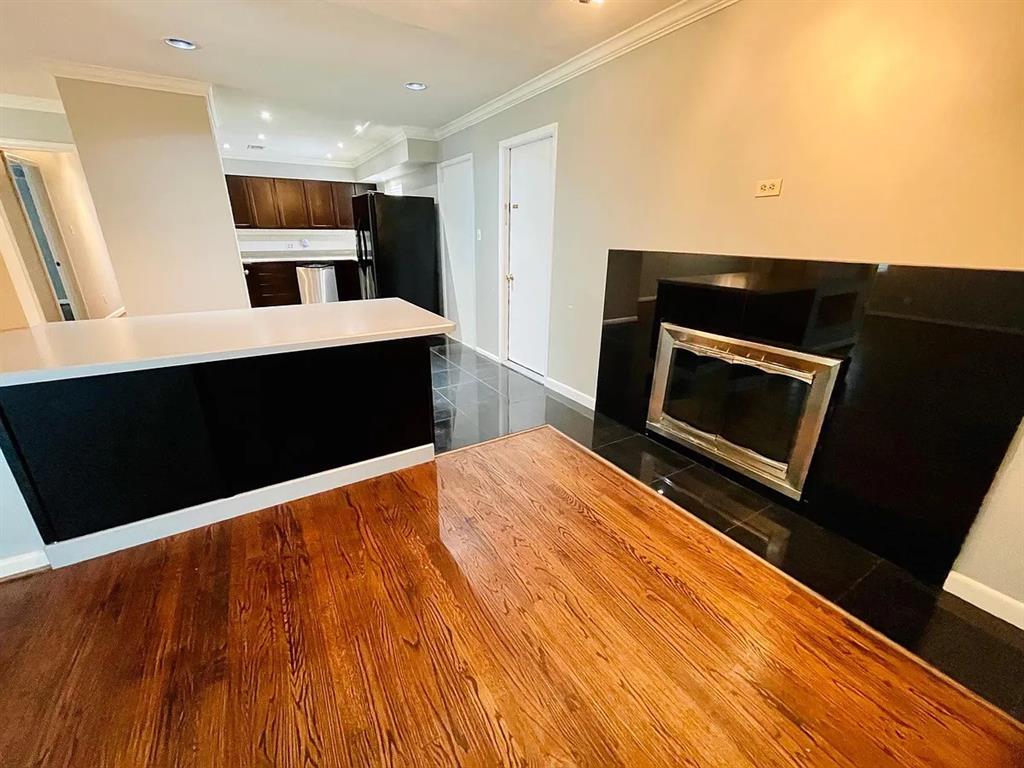 3152 Walnut Hill Lane Dallas, TX 75229 - Photo 8 of 18 a kitchen with stainless steel appliances kitchen island wooden cabinets and fireplace