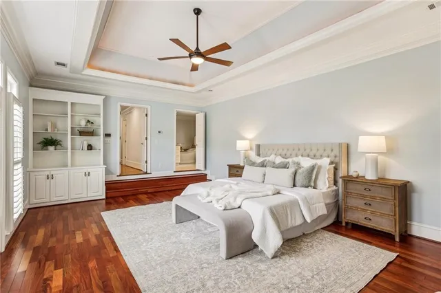 a spacious bedroom with a large bed and a chandelier