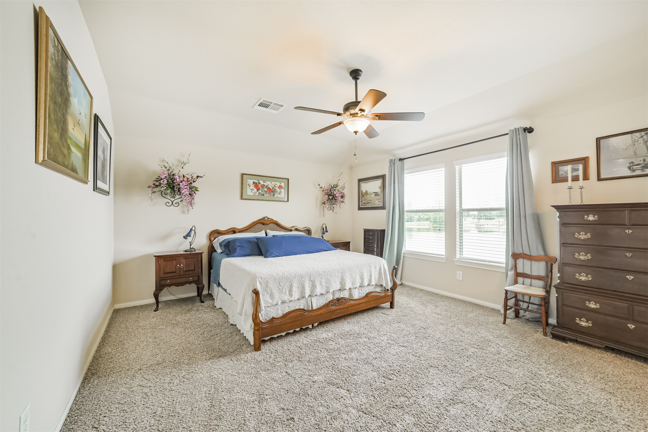 12009 La Salle River Road Conroe, TX 77304 - Photo 25 of 50 a spacious bedroom with a bed a dresser and a window
