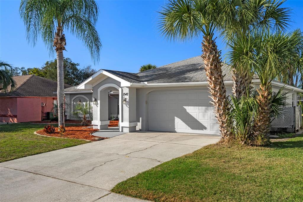 1542 Overland Drive Spring Hill, FL 34608 - Photo 2 of 58 a front view of a house with garden