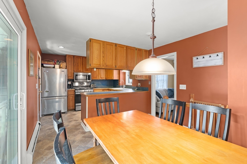 21 Francis Avenue Groveland, MA 01834 - Photo 9 of 29 a kitchen with stainless steel appliances granite countertop a refrigerator a sink dishwasher a stove and a dining table with wooden floor