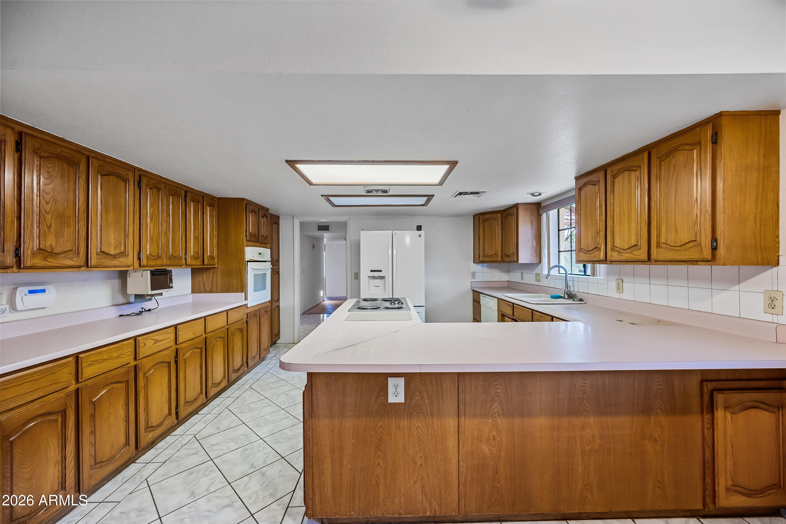 7358 Alamo Way Globe, AZ 85501 - Photo 24 of 68 a large kitchen with kitchen island granite countertop a sink counter space cabinets and a large window