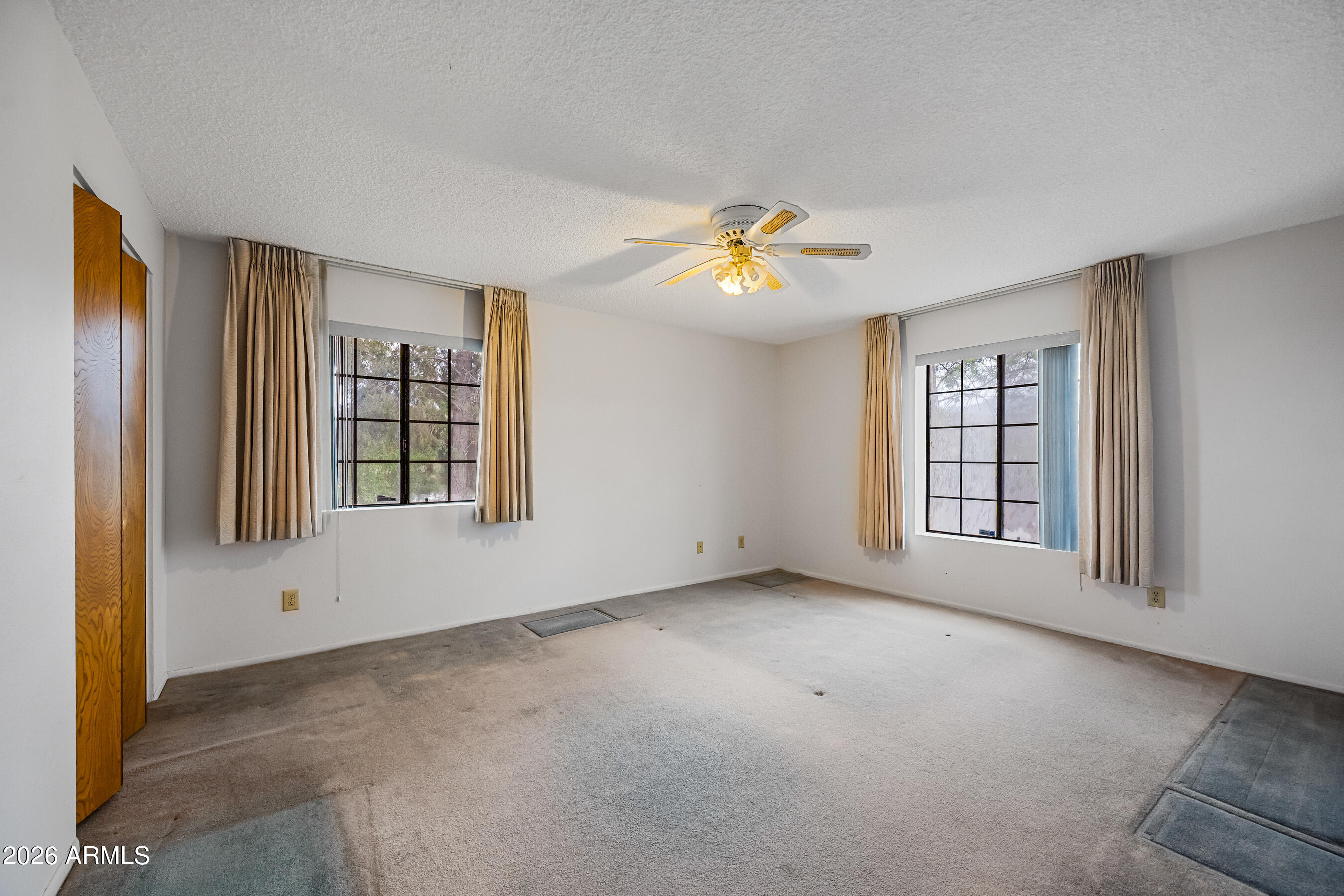 7358 Alamo Way Globe, AZ 85501 - Photo 37 of 68 an empty room with windows and ceiling fan