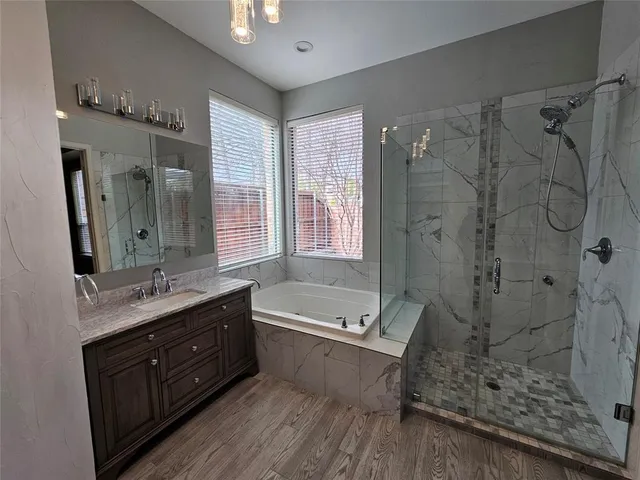 a bathroom with a tub sink shower and mirror