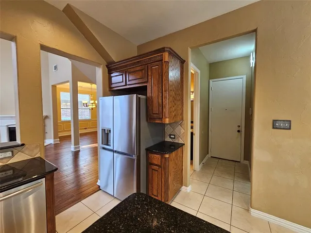 a kitchen with stainless steel appliances granite countertop a refrigerator and a stove
