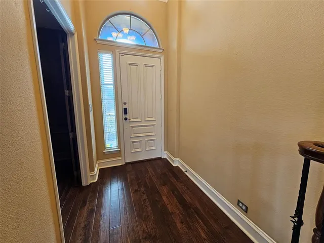 an empty room with wooden floor and a window