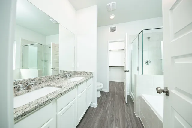 a spacious bathroom with a granite countertop sink mirror and a shower
