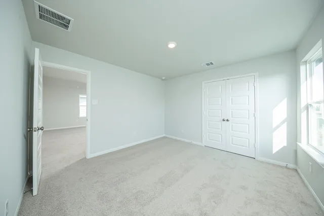 an empty room with windows and closet