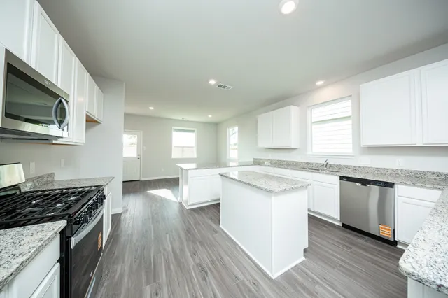 a kitchen with stainless steel appliances a stove sink and microwave