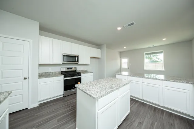 a kitchen with a sink stove and microwave