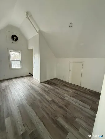a view of empty room with wooden floor
