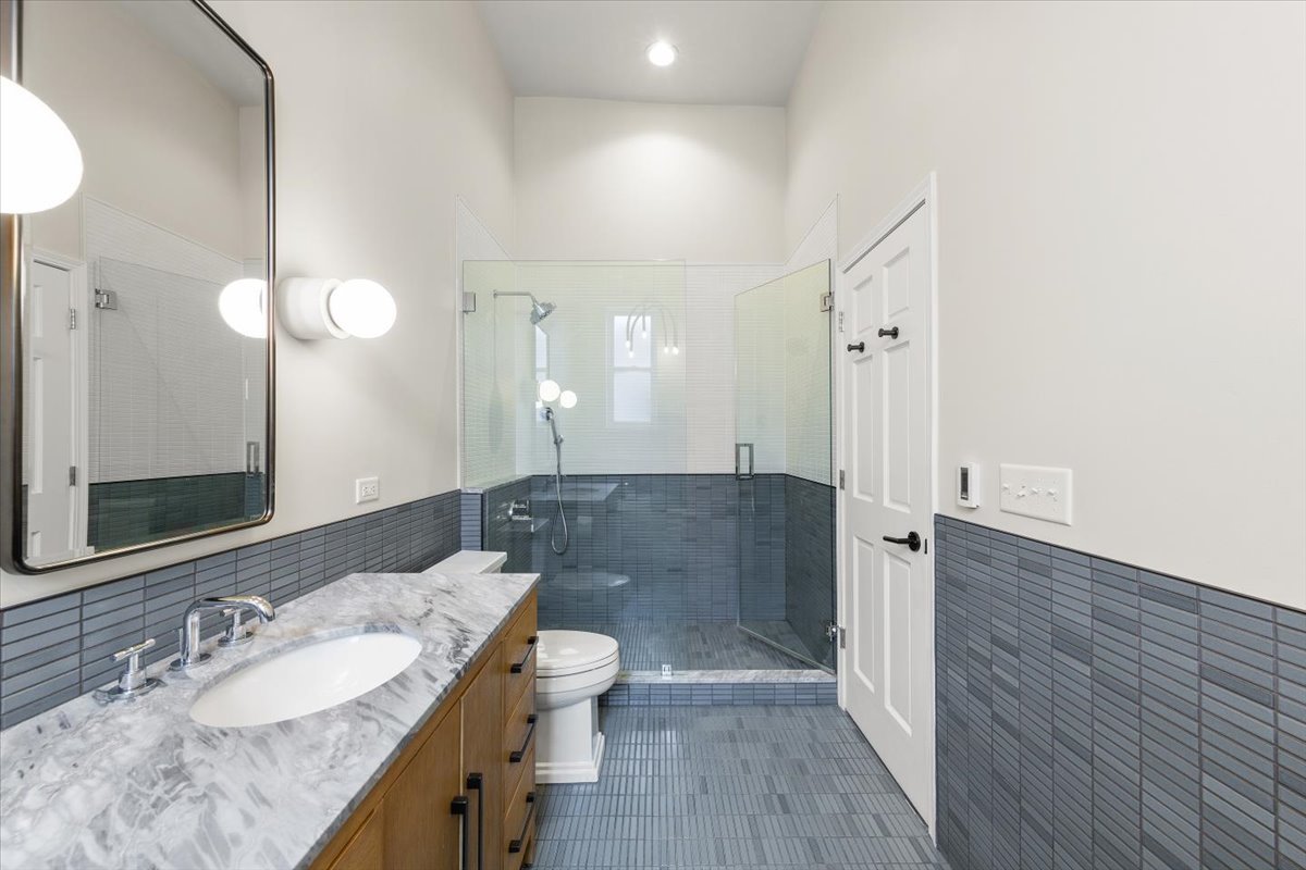 2849 North Burling Street, Unit 3 Chicago, IL 60657 - Photo 13 of 18 a bathroom with a granite countertop sink a toilet a mirror and shower